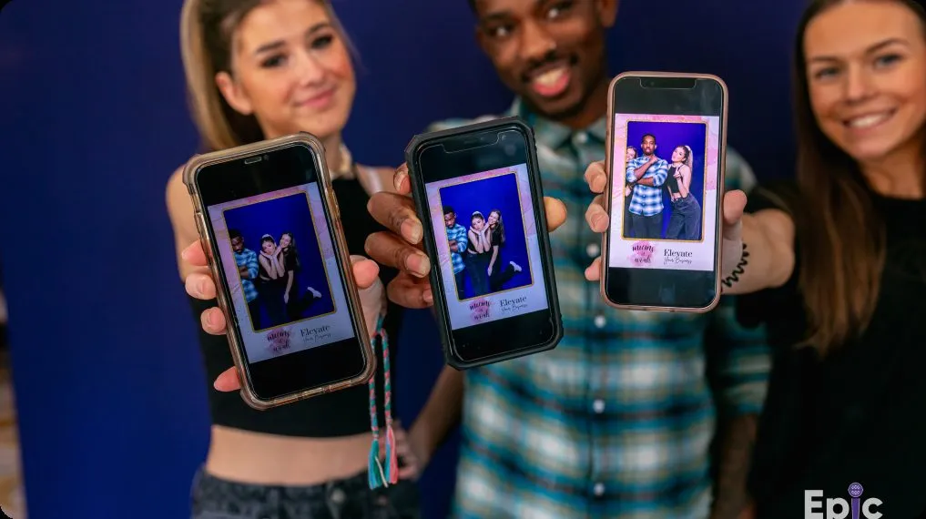 Guests sharing digital photo booth photos on their phones at a DMV event.