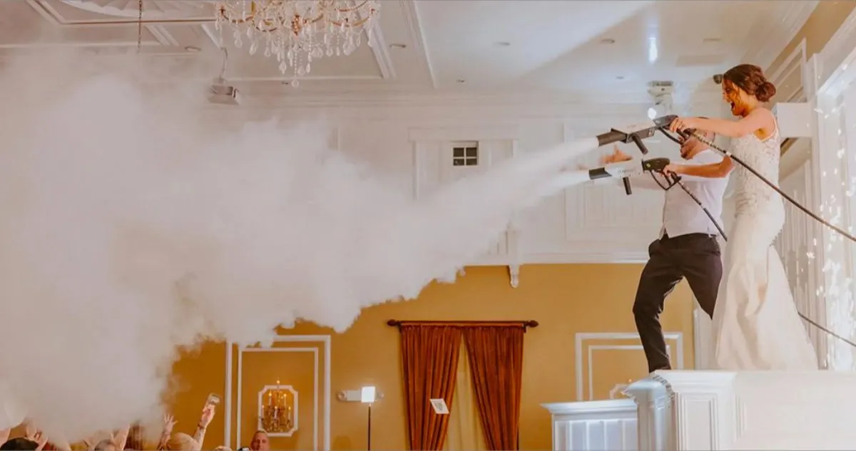 Bride and groom on a riser firing CO2 cannons over the dance floor as guests cheer.