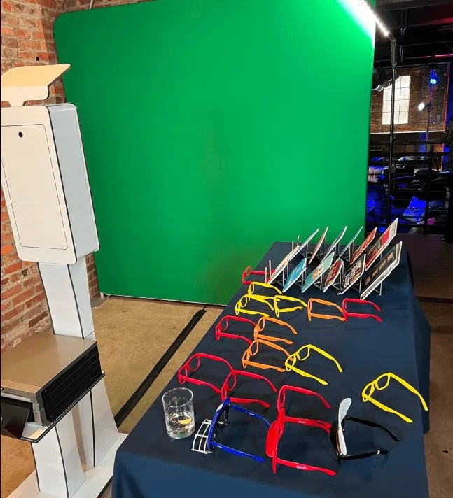 Green screen backdrop and photo booth camera set up in a ballroom before guests arrive.