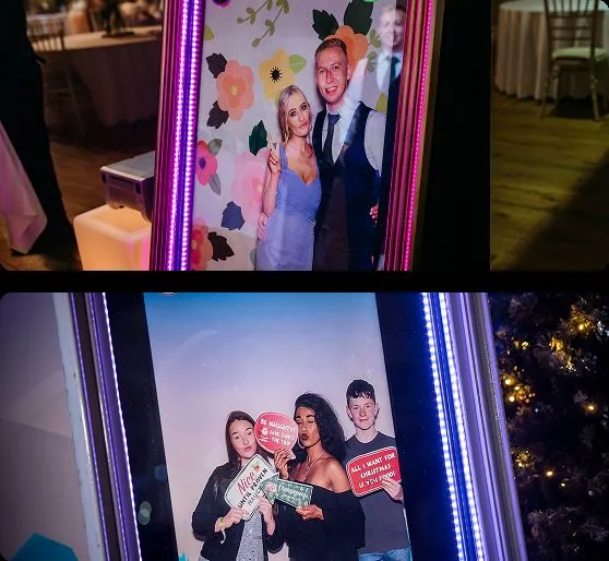 Newlyweds on a floral backdrop lounge at a DMV mirror photo booth.