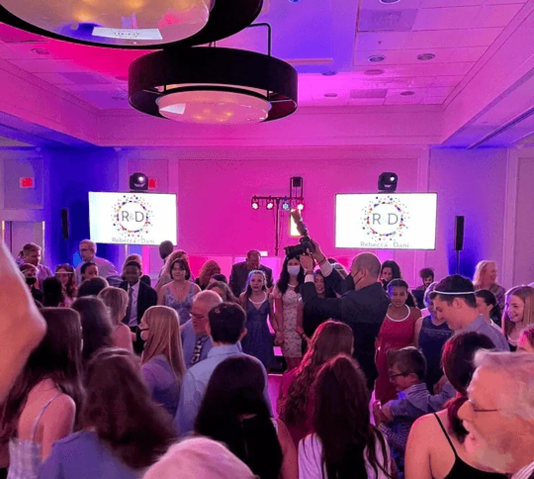 Full dance floor of mitzvah guests packed together facing the DJ booth.